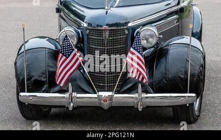 Griglia frontale e fari con due bandiere americane su una Coupe della General Motors Oldsmobile 1937 in una serata di primavera a Lindstrom, Minnesota USA. Foto Stock