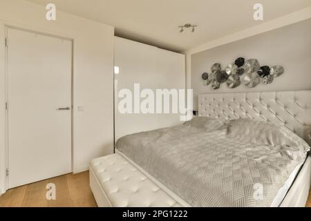 una camera da letto con un letto e due specchi sulla parete sopra che è davanti ad una porta aperta Foto Stock