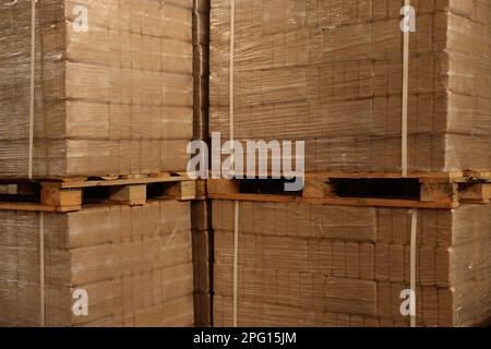 Pile di merce avvolte in film estensibile su pallet di legno Foto Stock