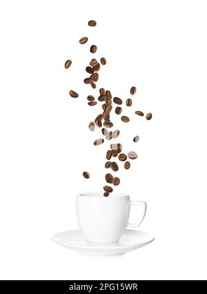 Chicchi di caffè arrostiti aromatici che cadono in tazza su sfondo bianco Foto Stock