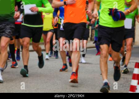 Gruppo intenzionalmente sfocato di corridori durante la corsa ideale come sfondo sportivo con molte persone Foto Stock