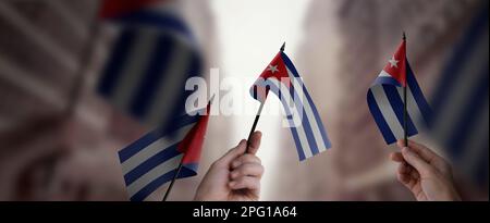 Un gruppo di persone che detengono nelle loro mani piccole bandiere della Cuba. Foto Stock