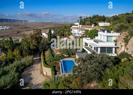 Gruppo di turbine eoliche dietro un'urbanizzazione e case di lusso a Zahara de los Atunes Costa de la Luz, provincia di Cadice, Andalusia. Foto Stock