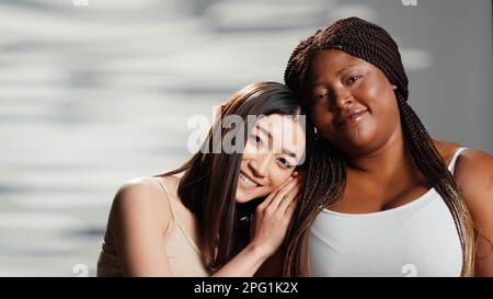 Ragazze interrazziali che esprimono positività e fiducia del corpo, gruppo di donne con diversi tipi di corpo e skintoni. Modelli curvy e skinny essendo naturale e allegro in studio. Foto Stock