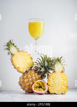succo di ananas in forma di composizione equilibrata con frutto della passione. Foto di alta qualità Foto Stock