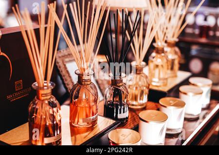 Bottiglie di vetro con barrette aromatiche diffonde su stand di legno nel centro commerciale. Decorazione domestica. Concetto di deodorante per ambienti. Foto Stock