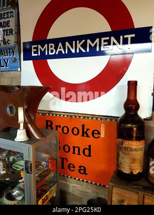 Interno di un antico emporio nell'Essex, Regno Unito, con un cartello london Underground Embankment e un cartello Brooke Bond Tea. Foto Stock