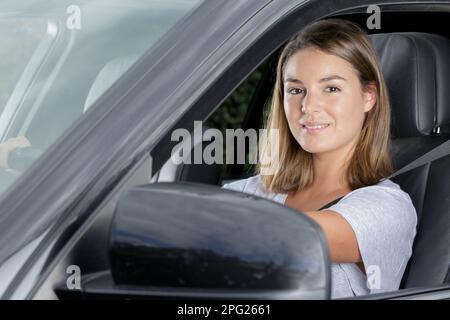 giovane donna è felice in macchina Foto Stock