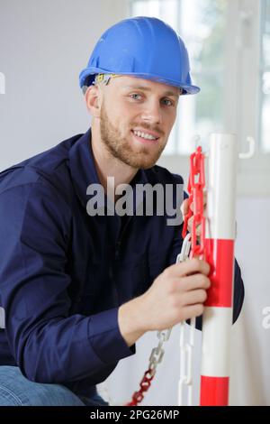 costruttore sorridente in un giubbotto protettivo Foto Stock