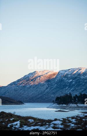 Vista delle montagne scozzesi al crepuscolo sul Loch Cluanie Foto Stock