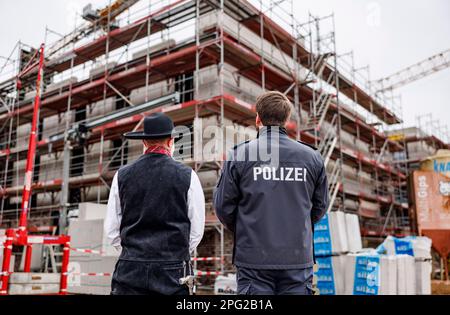 Eutin, Germania. 20th Mar, 2023. Un maestro falegname e un poliziotto guardano la conchiglia durante la cerimonia di rabbocco per la nuova costruzione di tre edifici di alloggio. Dall'estate 2024, fino a 350 poliziotti provenienti dalla polizia di formazione e polizia antisommossa possono essere accolti lì. Credit: Axel Heimken/dpa/Alamy Live News Foto Stock