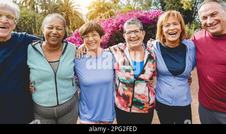 Persone anziane multirazziali divertirsi dopo l'allenamento esercizi all'aperto con parco cittadino in background - stile di vita sano e gioioso stile di vita anziano con Foto Stock