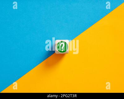 Simbolo del punto interrogativo su un pulsante a cubo di legno. Per selezionare tra le opzioni alternative. Dilemma, confusione e incertezza. Foto Stock