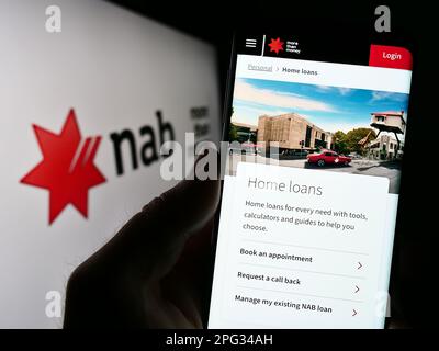 Persona che tiene il cellulare con il sito web della società National Australia Bank Limited (NAB) sullo schermo con il logo. Messa a fuoco al centro del display del telefono. Foto Stock