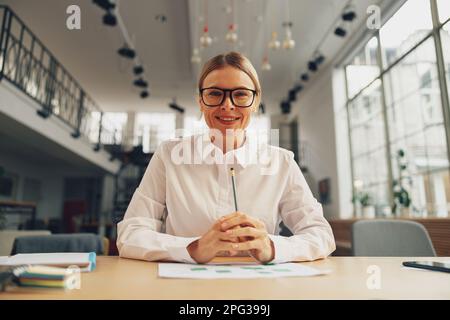 Il responsabile delle assunzioni di sesso femminile conduce un colloquio online con il candidato mentre è seduto sulla scrivania Foto Stock