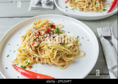 Pasta aglio e olio al tonno. Tagliatelle con olio d'oliva, aglio, prezzemolo e peperoncino. Cucina italiana Foto Stock