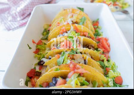 Casseruola Tex mex taco con carne macinata, fagioli rossi, pomodori, lattuga e farcitura di formaggio in una casseruola. Foto Stock