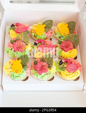 Confezione regalo con tortini di fenicotteri colorati e luminosi, frutta e fiori per feste di compleanno tropiche Foto Stock
