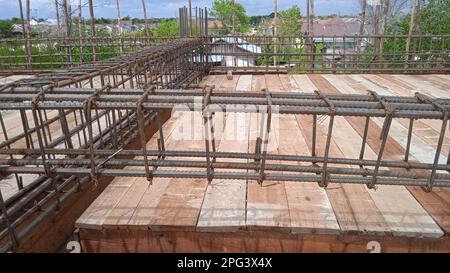 Lavoratore di costruzione che fa barra di acciaio di rinforzo Foto Stock