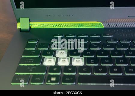 Kiev, Ucraina - 28 agosto 2022: ROG Strix G17 (Repubblica dei giocatori) laptop da gioco di ASUS. Pulsanti evidenziati con luce verde. Potente chiave per notebook Foto Stock