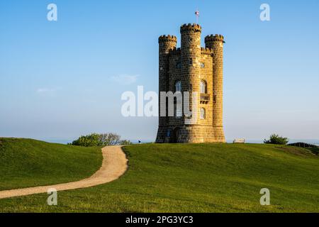 Il sole mattutino splende sulla follia della Broadway Tower nelle Cotswolds Hills in Inghilterra. Foto Stock