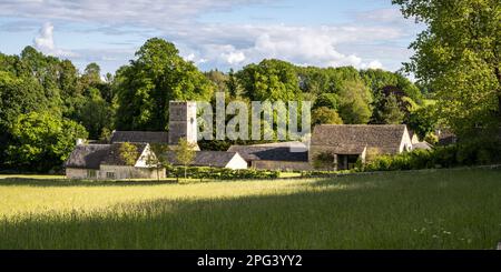 Il sole splende sulla torre della tradizionale chiesa del villaggio di Sant'Andrea a Coln Rogers, nelle Cotswolds inglesi. Foto Stock