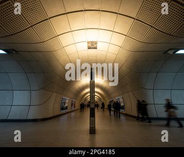 I passeggeri camminano attraverso i tunnel alla stazione di Tottenham Court Road sulla nuova linea ferroviaria della metropolitana Elizabeth Line di Londra. Foto Stock