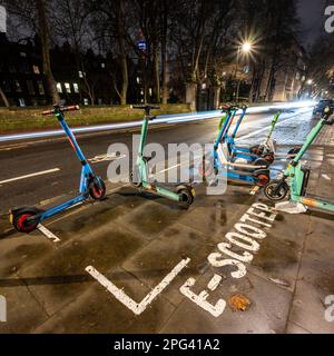 Gli scooter elettrici a noleggio presso una varietà di fornitori sono parcheggiati in un parcheggio segnato su a a Bloomsbury, Londra, nel tentativo di controllare i pavemen Foto Stock