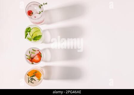Acque infuse con sapori diversi, bevande rinfrescanti estive in bicchieri a coste, spazio copia Foto Stock