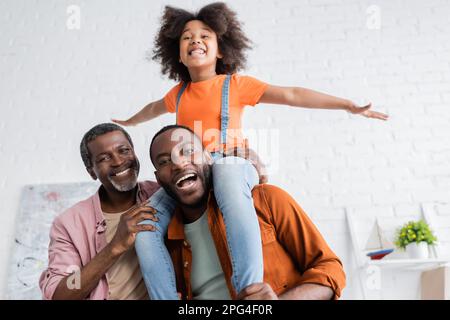 Uomini afroamericani positivi con bambino preadolescente che si divertono a casa, immagine stock Foto Stock