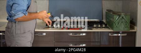 Immagine di un tecnico di handyman che con un rilevatore effettua controlli in cucina per la sicurezza e le perdite di gas dalla stufa. Prevenzione e sicurezza Foto Stock