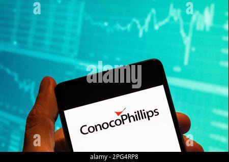 Cina. 15th Feb, 2023. In questa foto, il logo americano multinazionale idrocarburi ConocoPhillips visto visualizzato su uno smartphone con un grafico di indice di borsa economica in background. (Credit Image: © Budrul Chukrut/SOPA Images via ZUMA Press Wire) SOLO PER USO EDITORIALE! Non per USO commerciale! Foto Stock