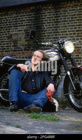 Attore Tim Woodward con la sua Triumph Bonneville classica moto Foto Stock