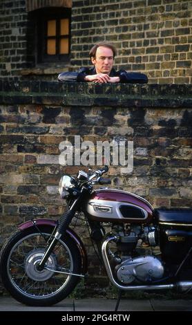 Attore Tim Woodward con la sua Triumph Bonneville classica moto Foto Stock