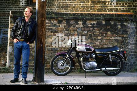 Attore Tim Woodward con la sua Triumph Bonneville classica moto Foto Stock