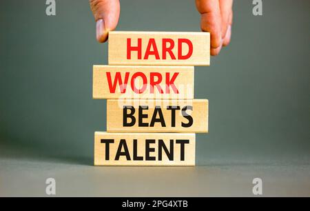 Il duro lavoro batte il simbolo del talento. Concetto parole duro lavoro batte il talento su woodenblock. Bellissimo sfondo grigio tavolo. Business motivazionale duro w Foto Stock