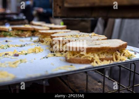 Panini con formaggio ed erbe in vendita su una teglia da forno in commercio Foto Stock