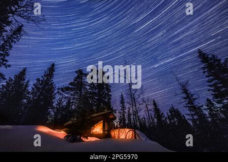 Una stella sopra una cabina remota nella neve in una foresta in Norvegia Foto Stock