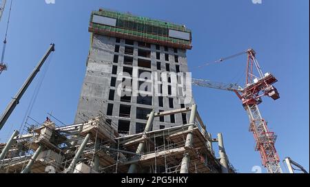 Costruzione di edifici con pavimenti in cemento utilizzando gru in città Foto Stock