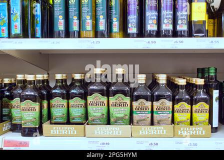 Scaffale del supermercato pieno di oli di raffreddamento compreso l'olio vergine di oliva Foto Stock