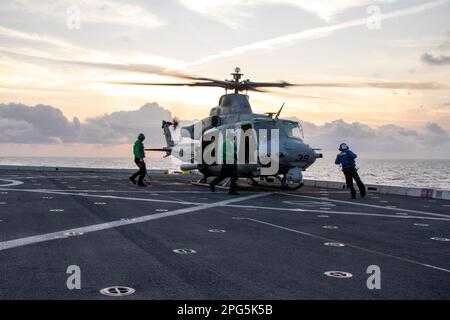 MARE DELLA CINA DEL SUD (16 marzo 2023) – i marinai scoccano e concatenano una UH-1Y Venom, assegnata a Marine Medium Tiltrotor Squadron (VMM) 362 (Rein.), 13th Marine Expeditionary Unit (MEU), dopo l'atterraggio sul molo di trasporto anfibio USS Anchorage (LPD 23) durante le operazioni di volo, 16 marzo 2023. La sincronizzazione delle capacità complementari dell'Anchorage 13th MEU e USS moltiplica l'influenza tradizionale dell'energia marina per produrre una forza più competitiva e letale. Il Makin Island Amphibious Ready Group, composto da nave d'assalto anfibio USS Makin Island (LHD 8) e bacini di trasporto anfibio USS A. Foto Stock