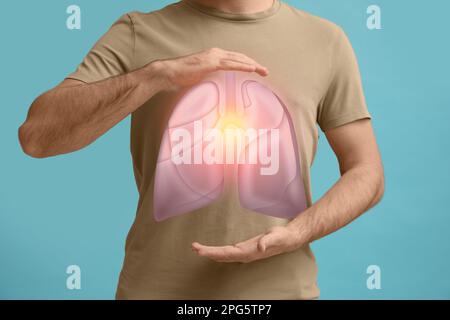 Uomo che tiene le mani vicino al petto con illustrazione dei polmoni su fondo turchese, primo piano Foto Stock