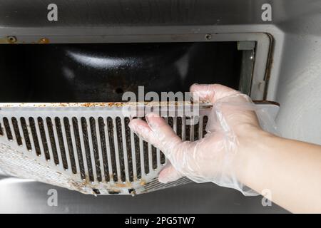 pulizia di una cappa filtrante oleosa da un ventilatore da cucina a composizione orizzontale Foto Stock