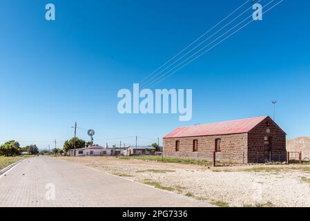 Campbell, Sudafrica - 24 febbraio 2023: Una scena di strada, con vecchi edifici, a Campbell. È visibile un mulino a vento Foto Stock