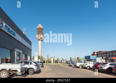 Kimberley, Sudafrica - 24 febbraio 2023: Una scena stradale, con veicoli e aziende visibili, a Kimberley. La torre per telecomunicazioni a microonde è Foto Stock