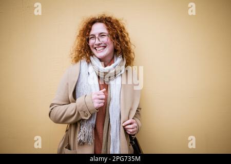 Ritratto naturale di donna zenzero caucasica sorridente con lenticelle e capelli ricci. Foto Stock