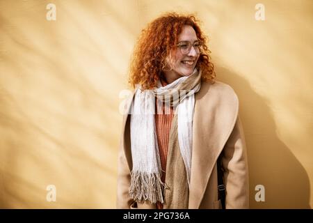 Ritratto naturale di donna zenzero caucasica sorridente con lenticelle e capelli ricci. Foto Stock