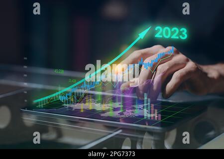 L'uomo d'affari utilizza il tablet per analizzare la crescita del grafico economico freccia dati 2023 delle vendite aziendali. Pianificazione e strategia. Analisi Forex trading. Finanza e ba Foto Stock