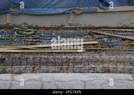 Vecchia rete di acciaio di rinforzo arrugginita in un cantiere Foto Stock