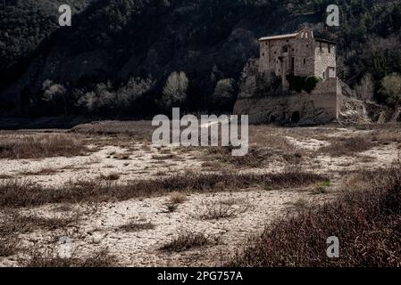 L'antico monastero romanico di Sant Salvador de la Vedella, che normalmente è circondato dall'acqua, è visto sul letto secco del fiume Llobregat mentre entra nel bacino idrico di la Baells a Cercs, nella provincia di Barcellona, in Spagna. Le restrizioni idriche sono state ulteriormente rafforzate in Catalogna a causa della siccità in corso, che è ormai da 29 mesi e che è legata al cambiamento climatico e al riscaldamento globale. Attualmente, i serbatoi catalani sono al 27 per cento della loro capacità. Foto Stock